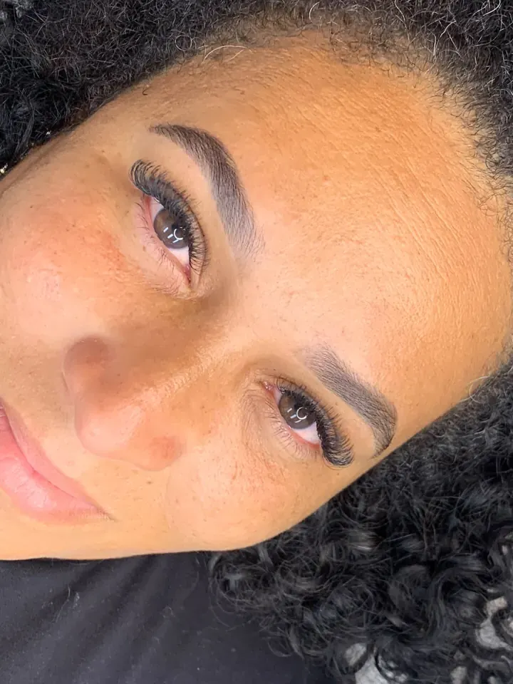 Cliente de cabelo cacheado com extensão de cílios híbrida